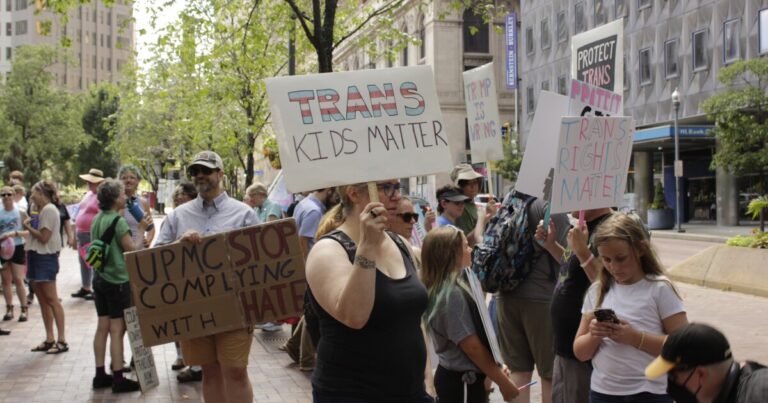 UPMC 건물 앞에서 트랜스 건강 관리를 지원하는 랠리 옹호자 
    


